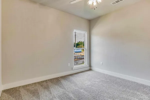 a view of an empty room with a window and a livingroom