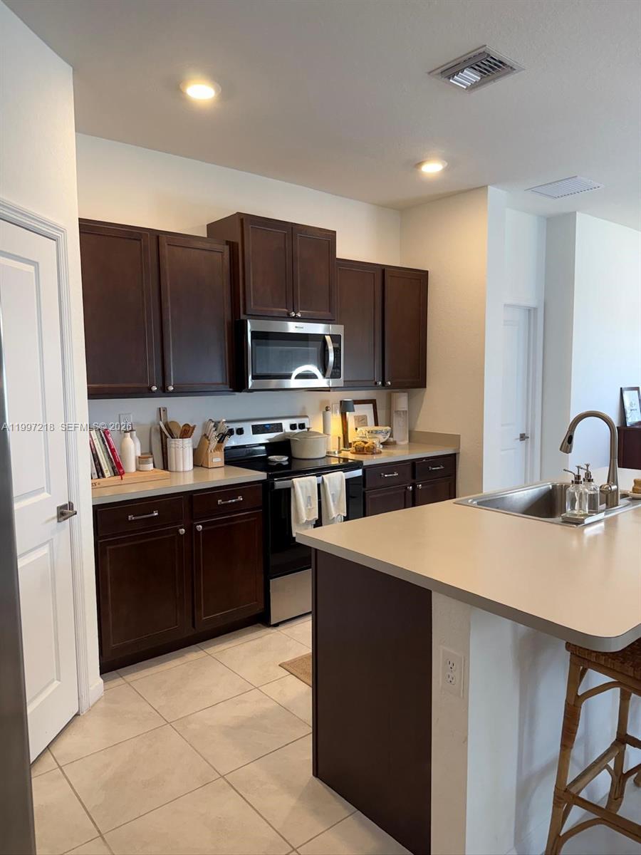 13233 Southwest 272nd Street Homestead, FL 33032 - Photo 11 of 21 a kitchen with stainless steel appliances a refrigerator stove microwave and sink