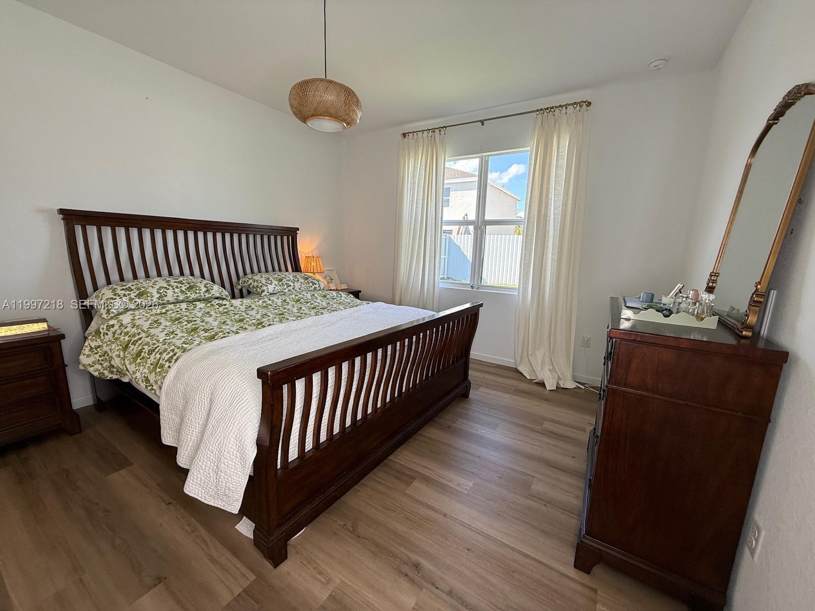 13233 Southwest 272nd Street Homestead, FL 33032 - Photo 12 of 21 a bedroom with a bed and wooden floor