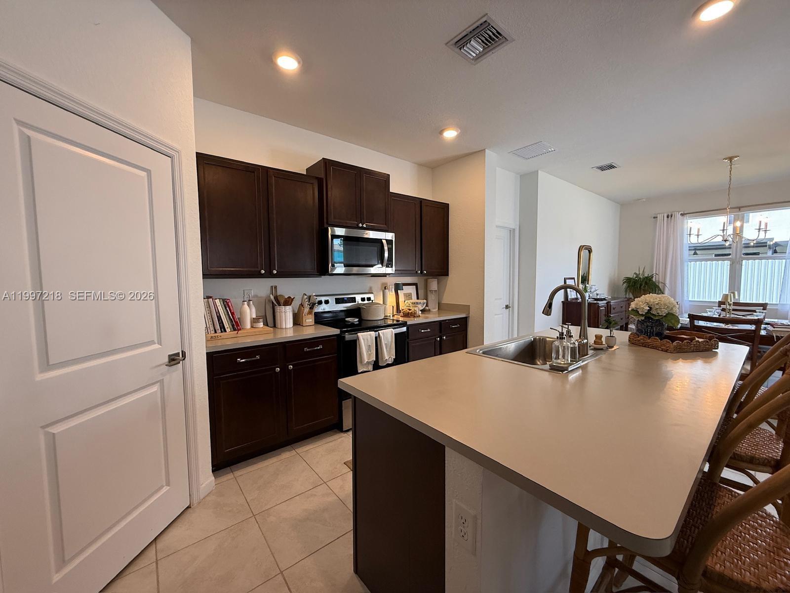 13233 Southwest 272nd Street Homestead, FL 33032 - Photo 10 of 21 a large kitchen with kitchen island a large counter top stainless steel appliances and cabinets