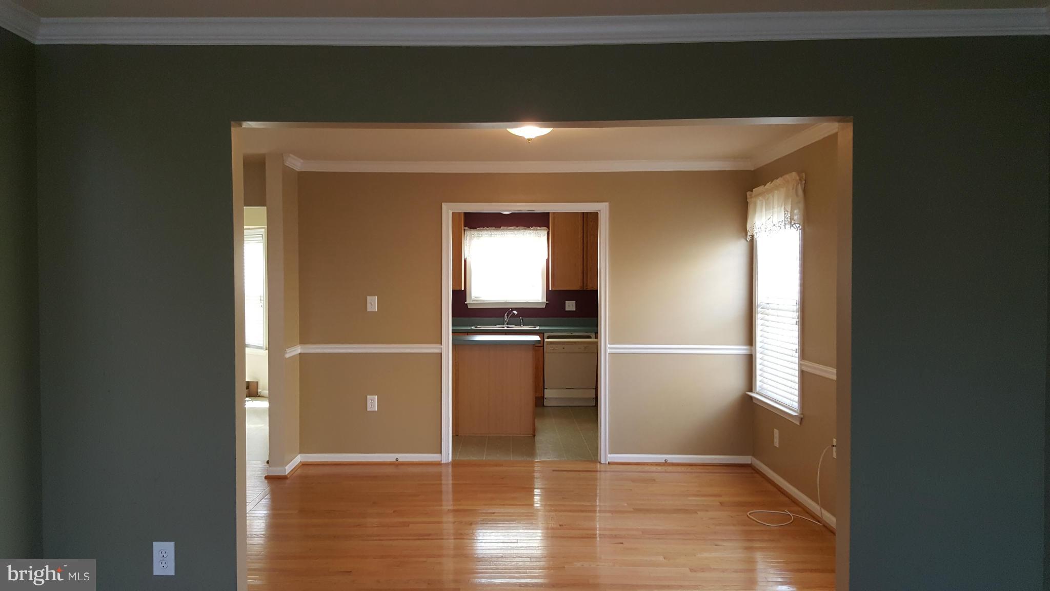 102 Limited Drive Ranson, WV 25438 - Photo 7 of 23 a view of a hallway with wooden floor and a kitchen