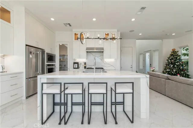 a kitchen with white cabinets and stainless steel appliances