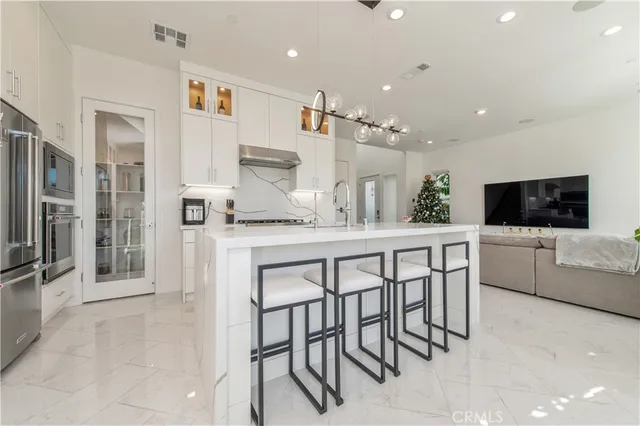 a kitchen with stainless steel appliances kitchen island granite countertop a table and chairs