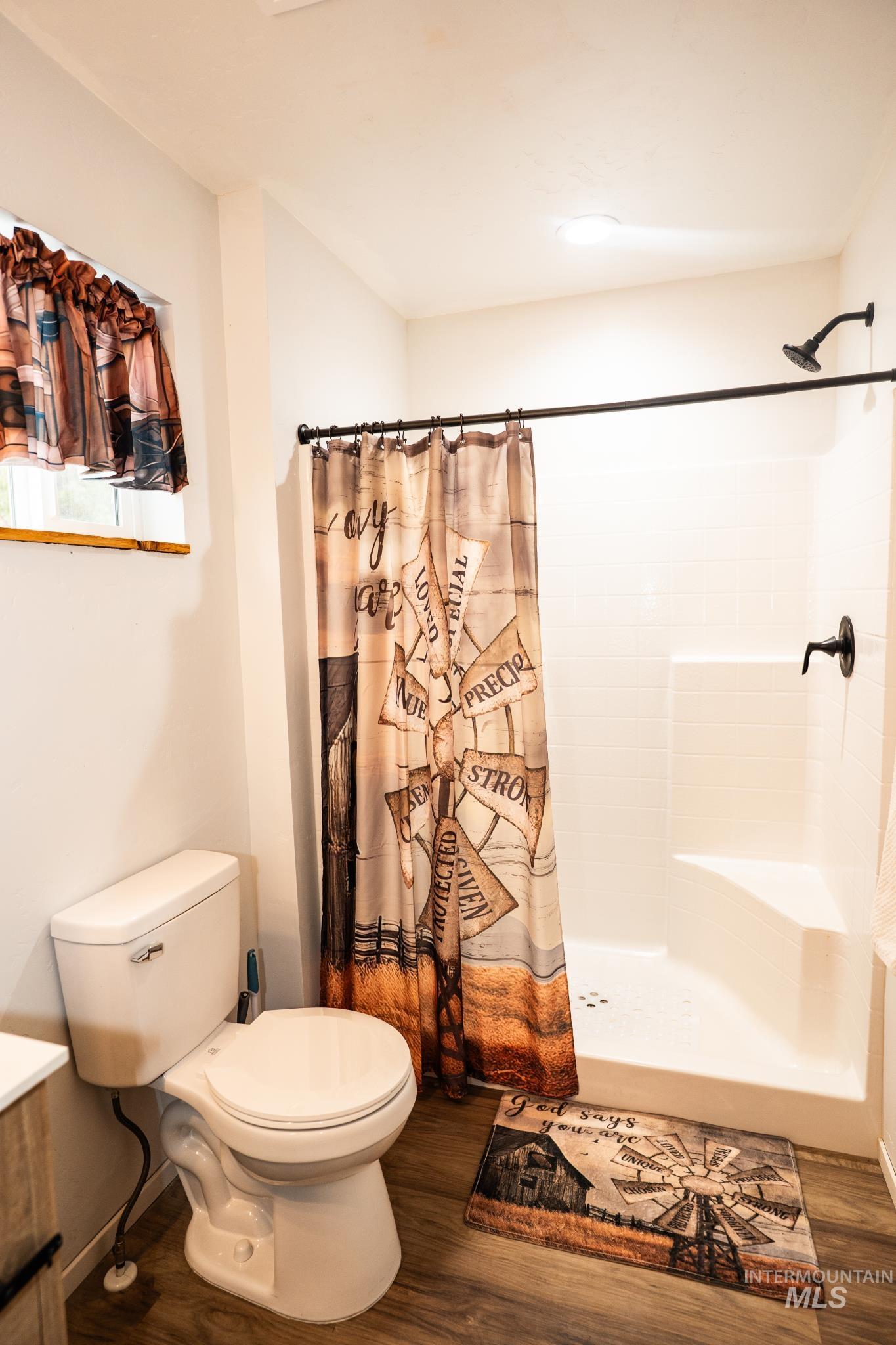 22 West Prospectors Drive Cascade, ID 83611 - Photo 17 of 29 Full bathroom featuring vanity, curtained shower, and dark wood-type flooring