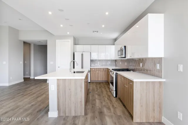 a large kitchen with stainless steel appliances lots of counter space and wooden floor