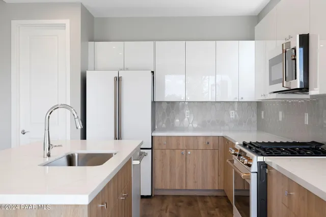 a kitchen with stainless steel appliances granite countertop a sink stove and refrigerator