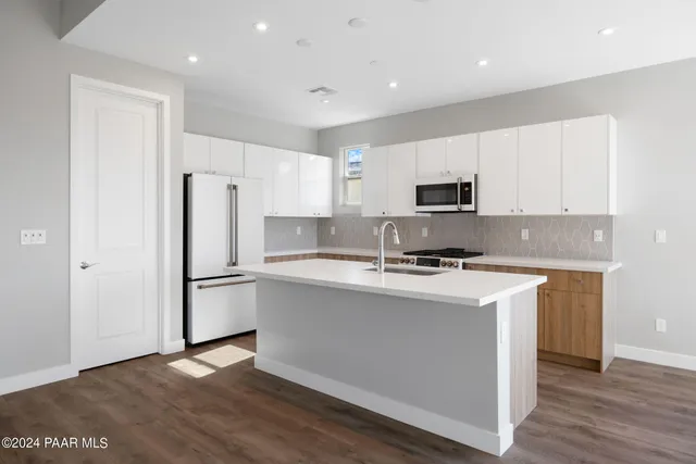 a kitchen with stainless steel appliances a refrigerator stove microwave and sink