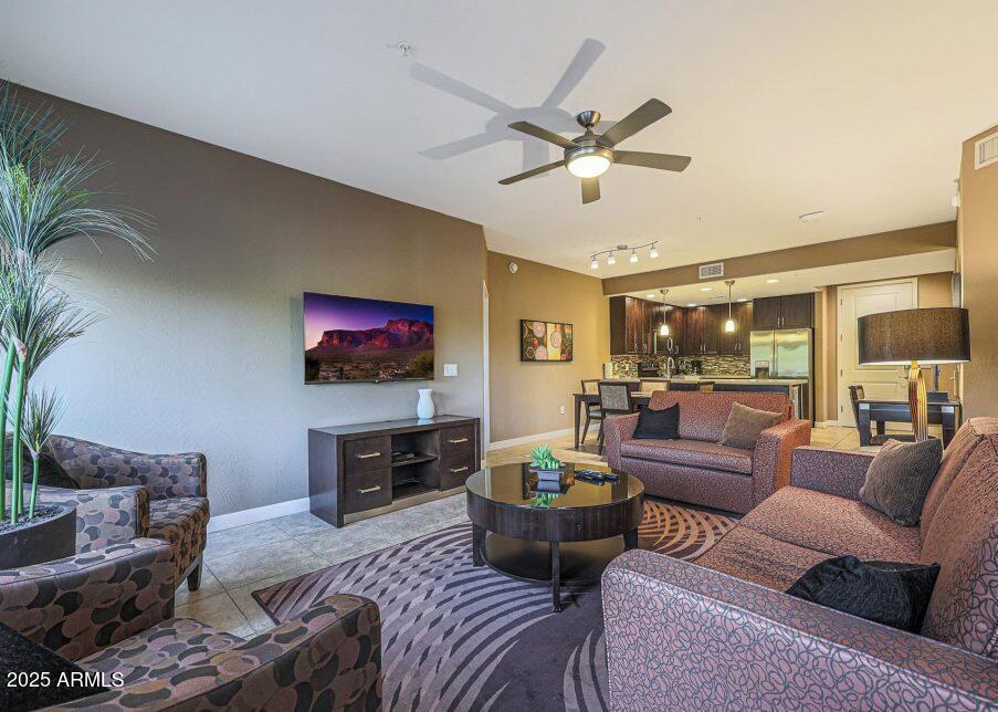 5450 East Deer Valley Drive, Unit 2191 Phoenix, AZ 85054 - Photo 11 of 50 a living room with furniture a ceiling fan and a flat screen tv