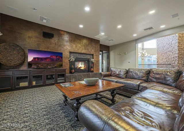 a living room with furniture a flat screen tv and a fireplace