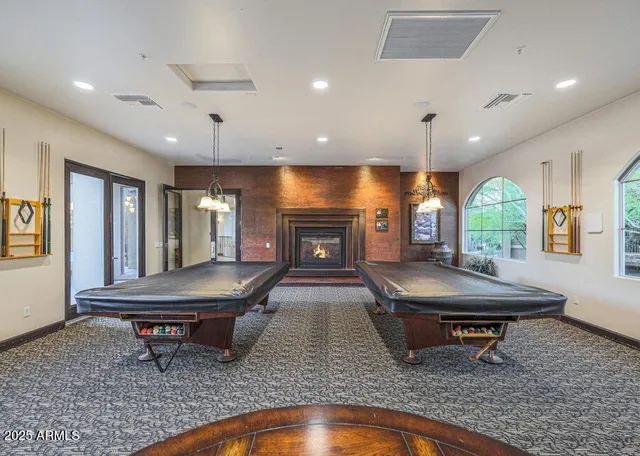 a living room with furniture a pool table and a fireplace