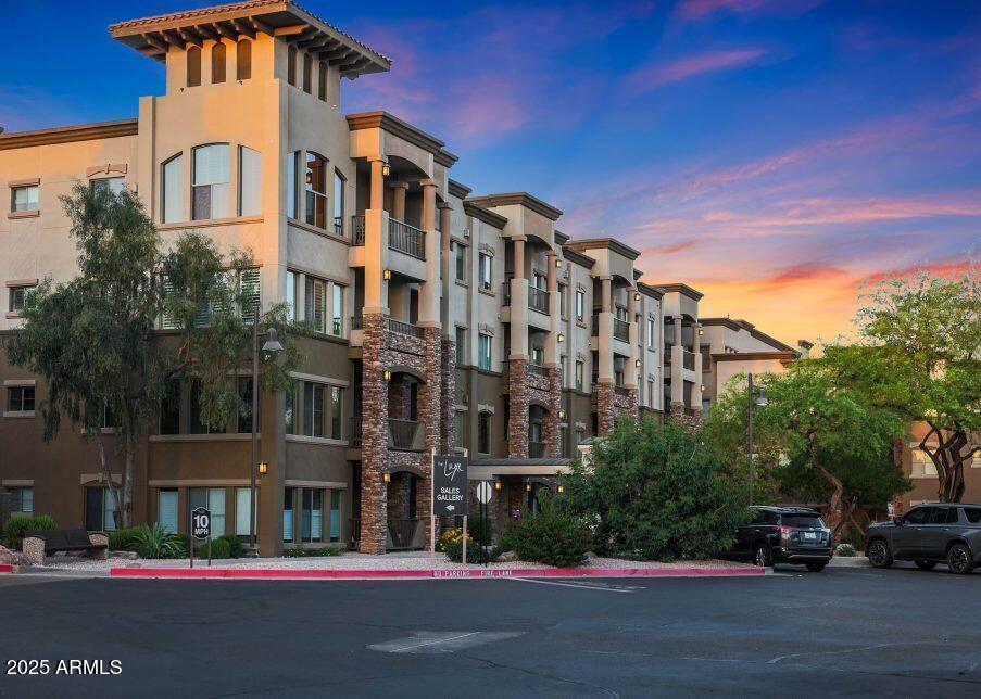 5450 East Deer Valley Drive, Unit 2191 Phoenix, AZ 85054 - Photo 44 of 50 a front view of a building with lot of cars and trees
