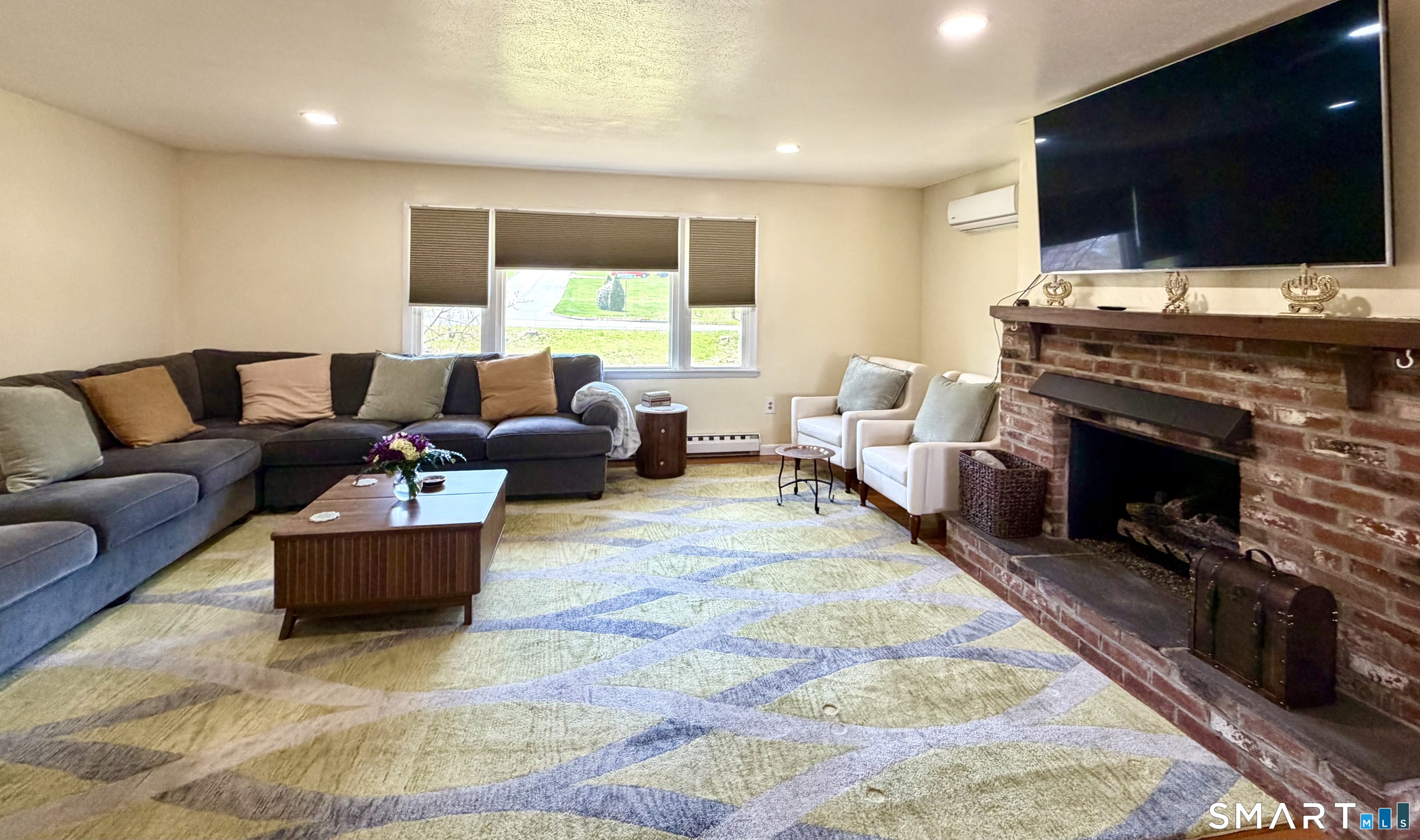 277 Windsorville Road Ellington, CT 06029 - Photo 16 of 40 a living room with furniture a flat screen tv and a fireplace