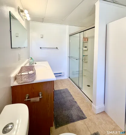 a bathroom with a sink a toilet and shower