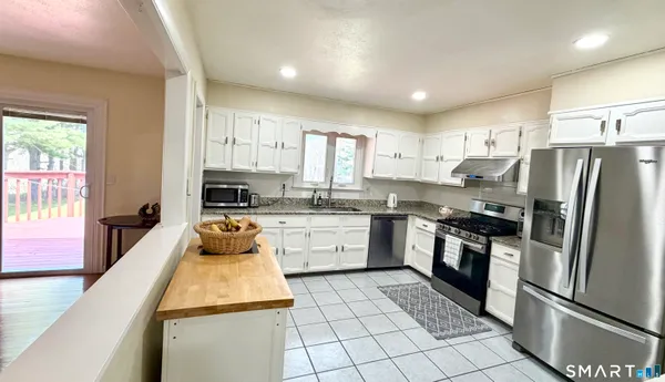 a kitchen with a refrigerator sink and cabinets