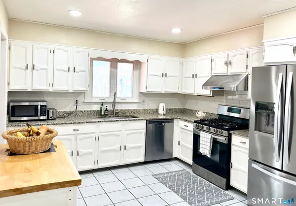 a kitchen with stainless steel appliances granite countertop a stove a sink and a refrigerator