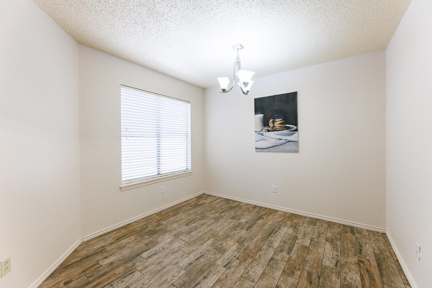 3316 79th Street Lubbock, TX 79423 - Photo 11 of 45 wooden floor in an empty room with a window
