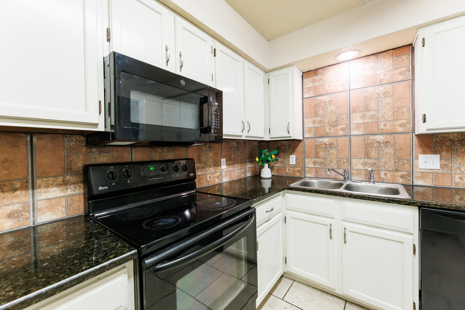 3316 79th Street Lubbock, TX 79423 - Photo 17 of 45 a kitchen with stainless steel appliances a stove a microwave a sink and cabinets