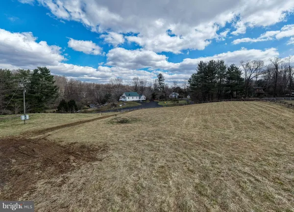 a view of a dry yard with wooden fence