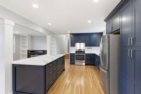 a large kitchen with a large counter top stainless steel appliances and cabinets