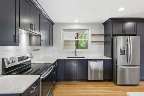 a kitchen with stainless steel appliances granite countertop a sink stove and refrigerator