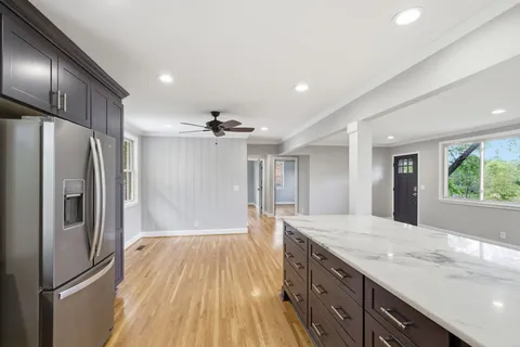a kitchen with stainless steel appliances granite countertop a refrigerator and a sink