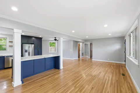 a view of a big room with wooden floor and windows
