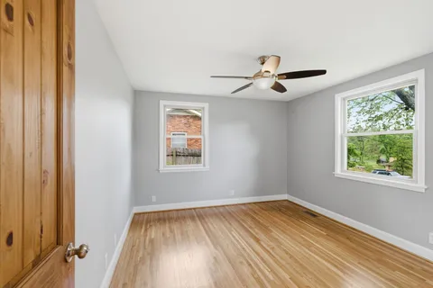 a view of empty room with window and ceiling fan