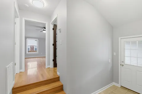 a view of a hallway with wooden floor and staircase