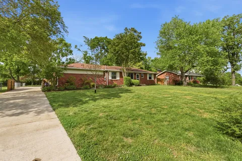 a view of house with garden and trees