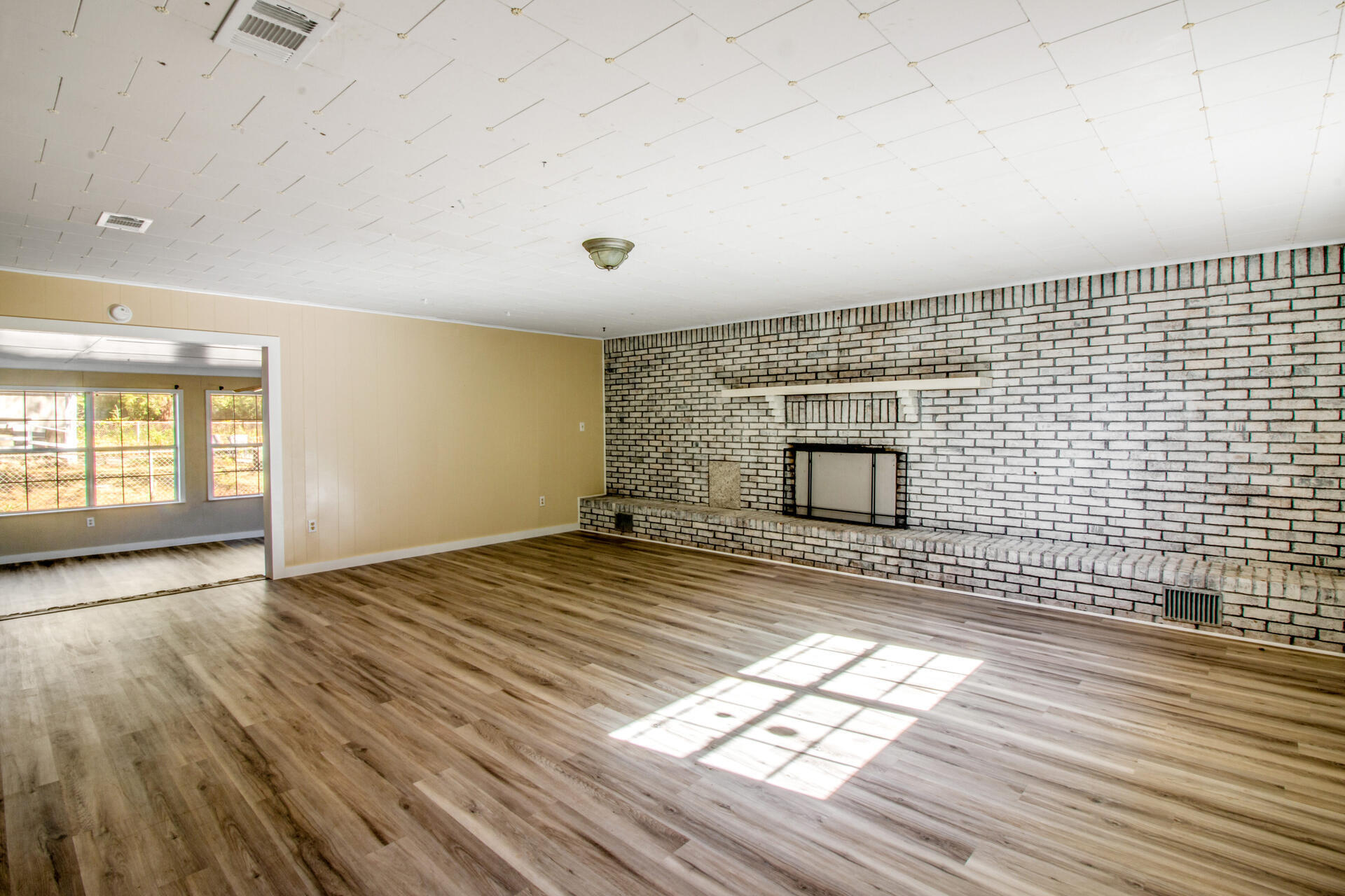 697 Long Drive Crestview, FL 32539 - Photo 11 of 26 an empty room with wooden floor and windows