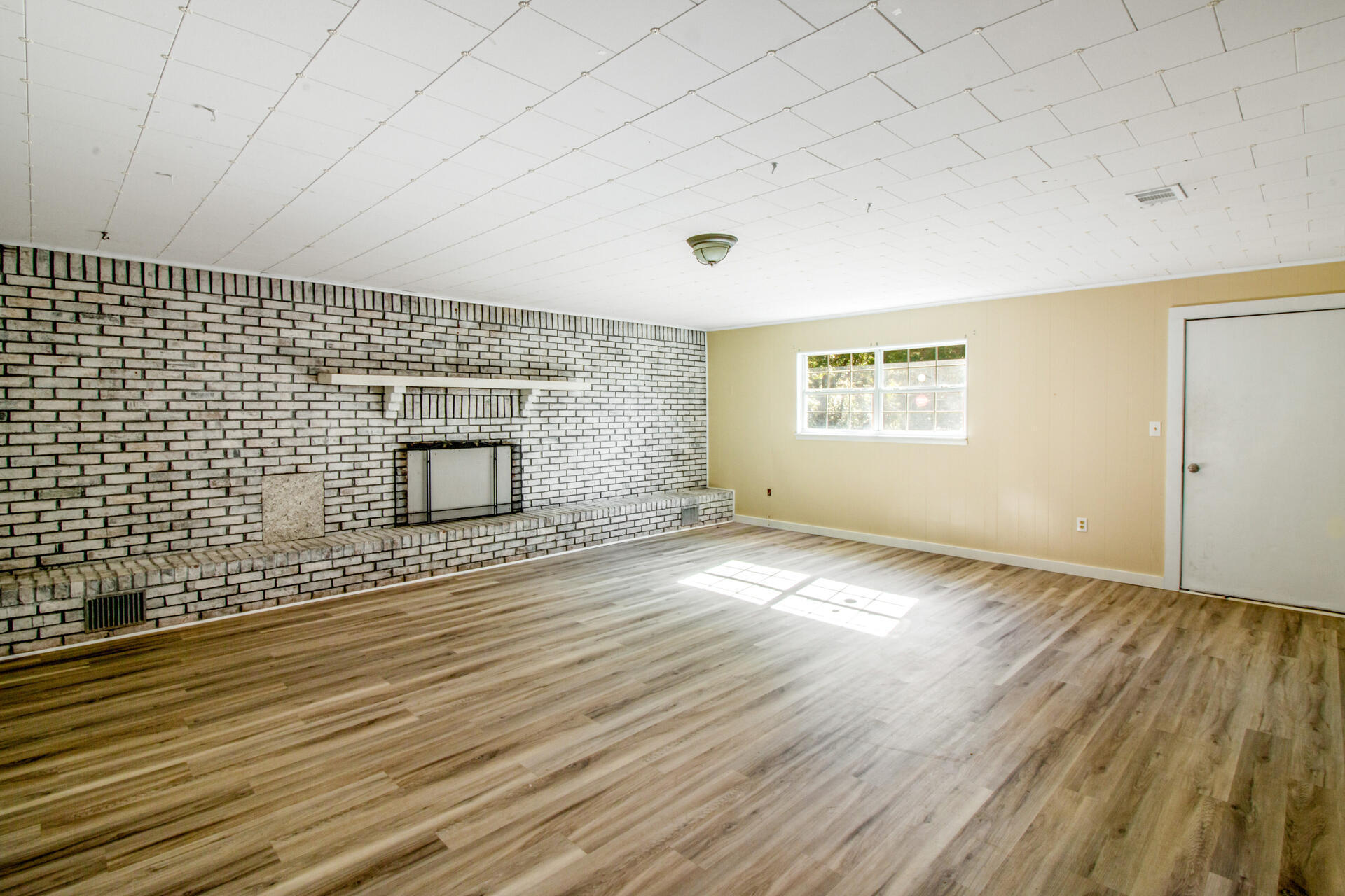 697 Long Drive Crestview, FL 32539 - Photo 13 of 26 an empty room with wooden floor and windows