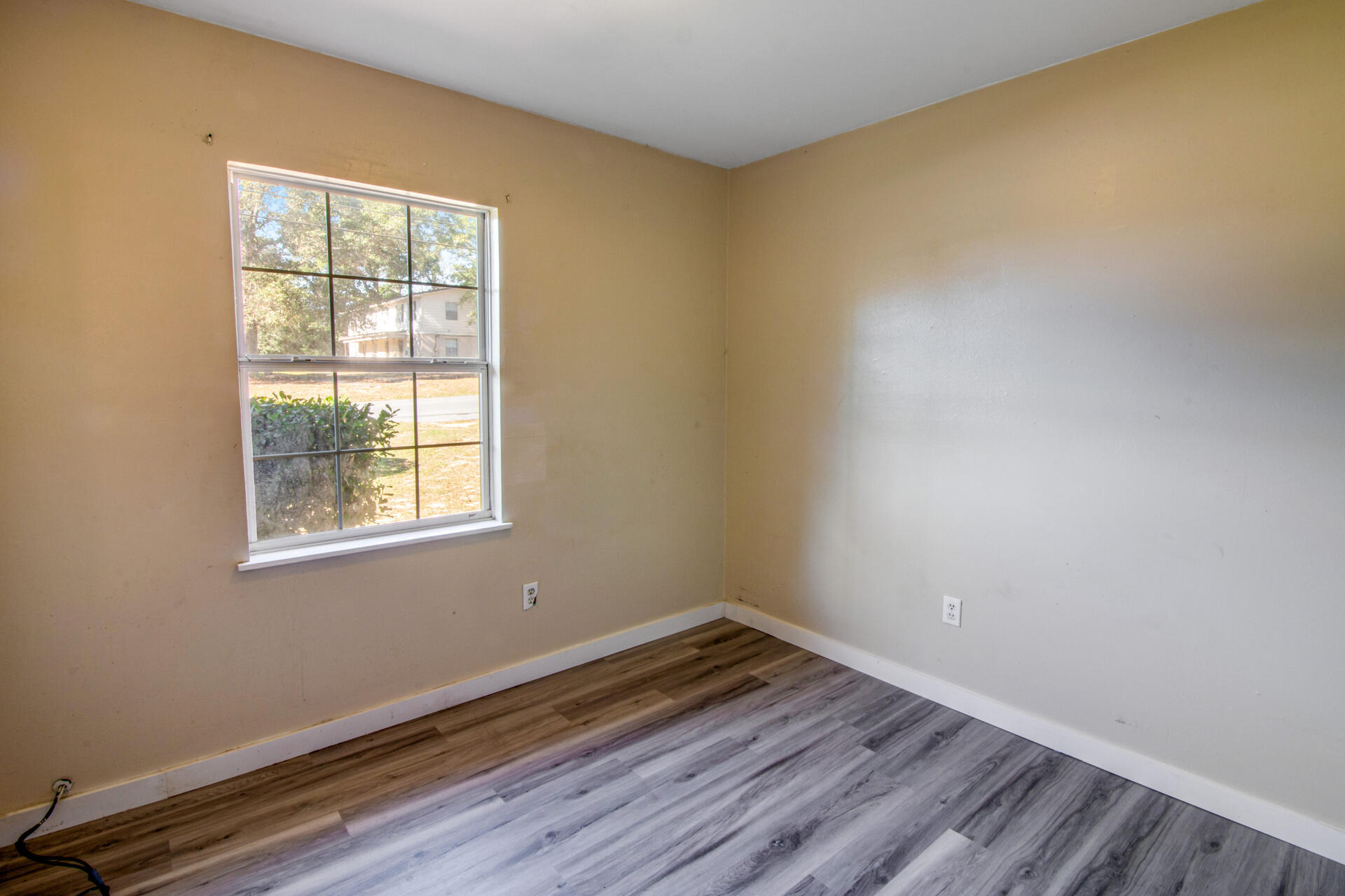 697 Long Drive Crestview, FL 32539 - Photo 17 of 26 an empty room with wooden floor and windows