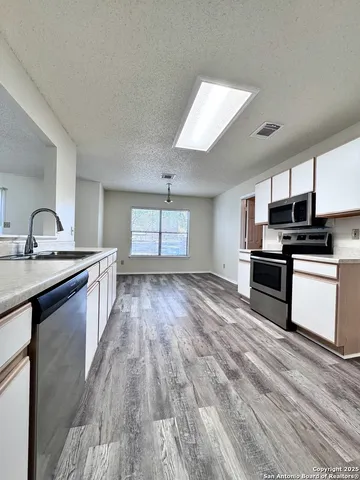 a kitchen with granite countertop a sink and steel appliances
