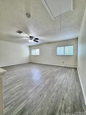 a view of empty room with wooden floor