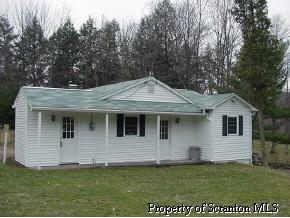 87 Hillbilly Road Tunkhannock, PA 18657 - Photo 1 of 2 a front view of a house with a garden