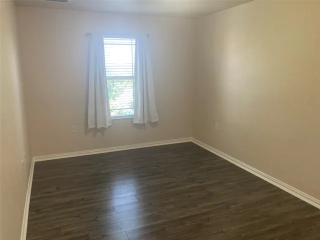 a view of a room with wooden floor