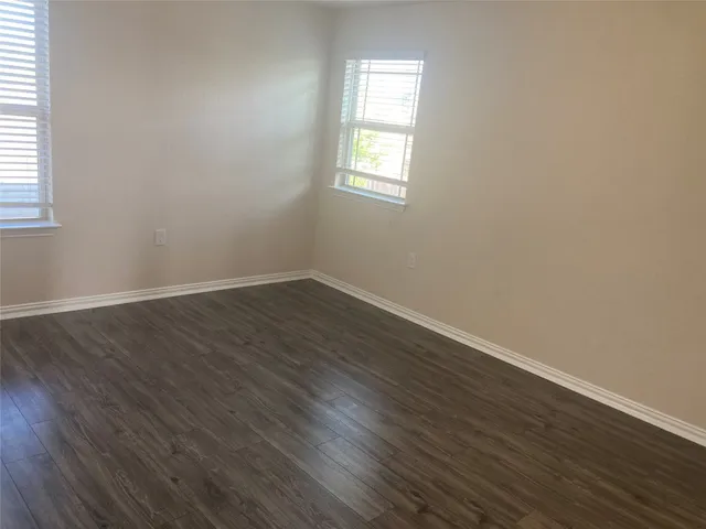 an empty room with wooden floor and closet