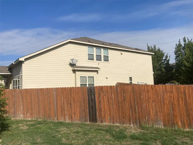 a view of backyard with small cabin and wooden fence