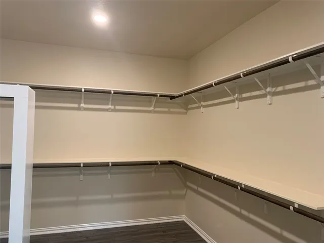 a view of walk in closet with empty racks