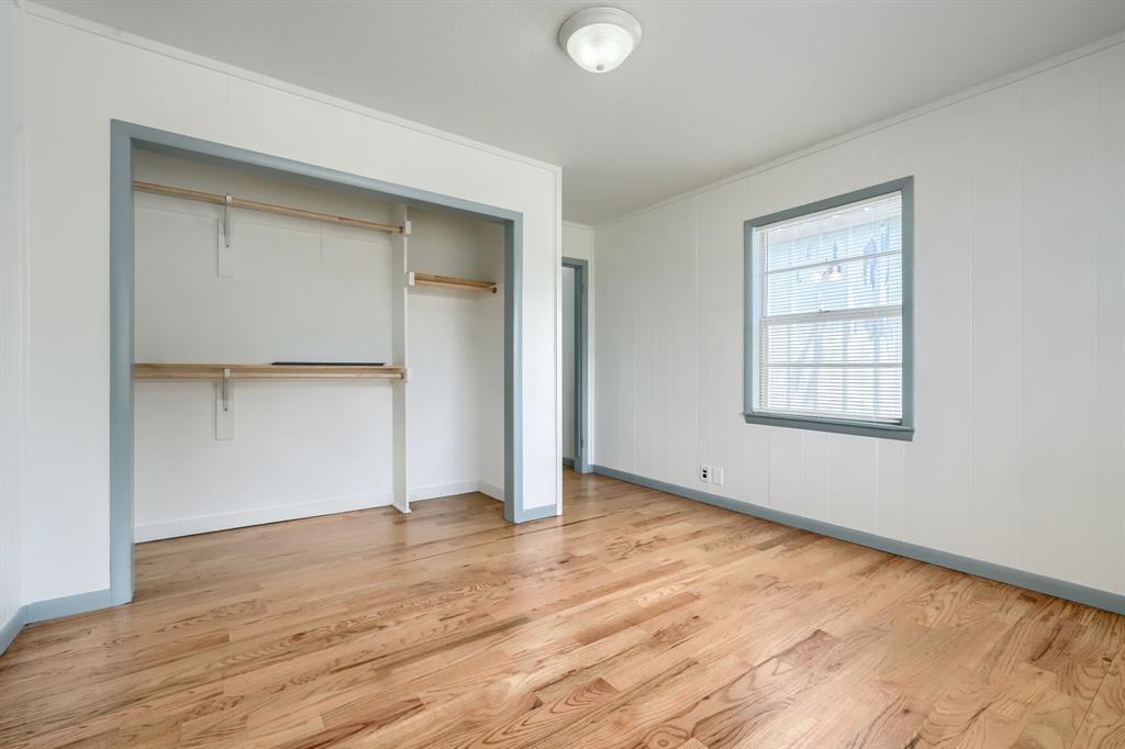 1802 Refinery Road Gainesville, TX 76240 - Photo 21 of 27 Room featuring wood-finish flooring, white paneling, and a light-colored window frame with blinds