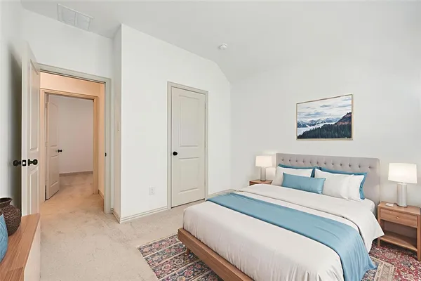a bedroom with a bed and a painting on the wall