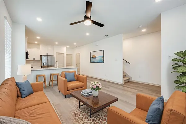 a living room with furniture and a view of kitchen