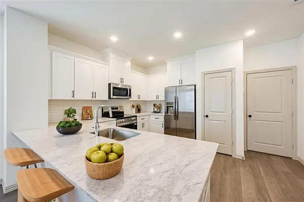 a kitchen with stainless steel appliances granite countertop a refrigerator and a sink