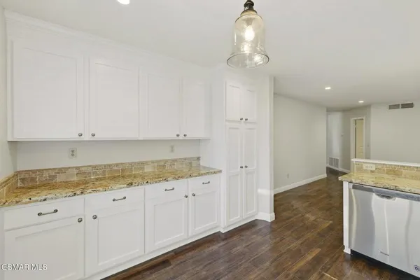 a kitchen with granite countertop white cabinets and white appliances