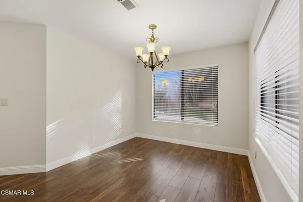 a view of a room with wooden floor chandelier and a window