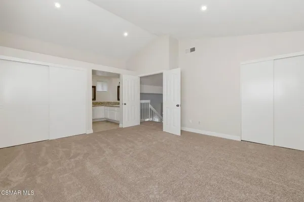 a view of empty room with kitchen and window