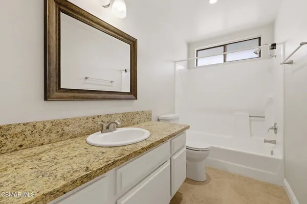 a bathroom with a granite countertop sink toilet and a bathtub