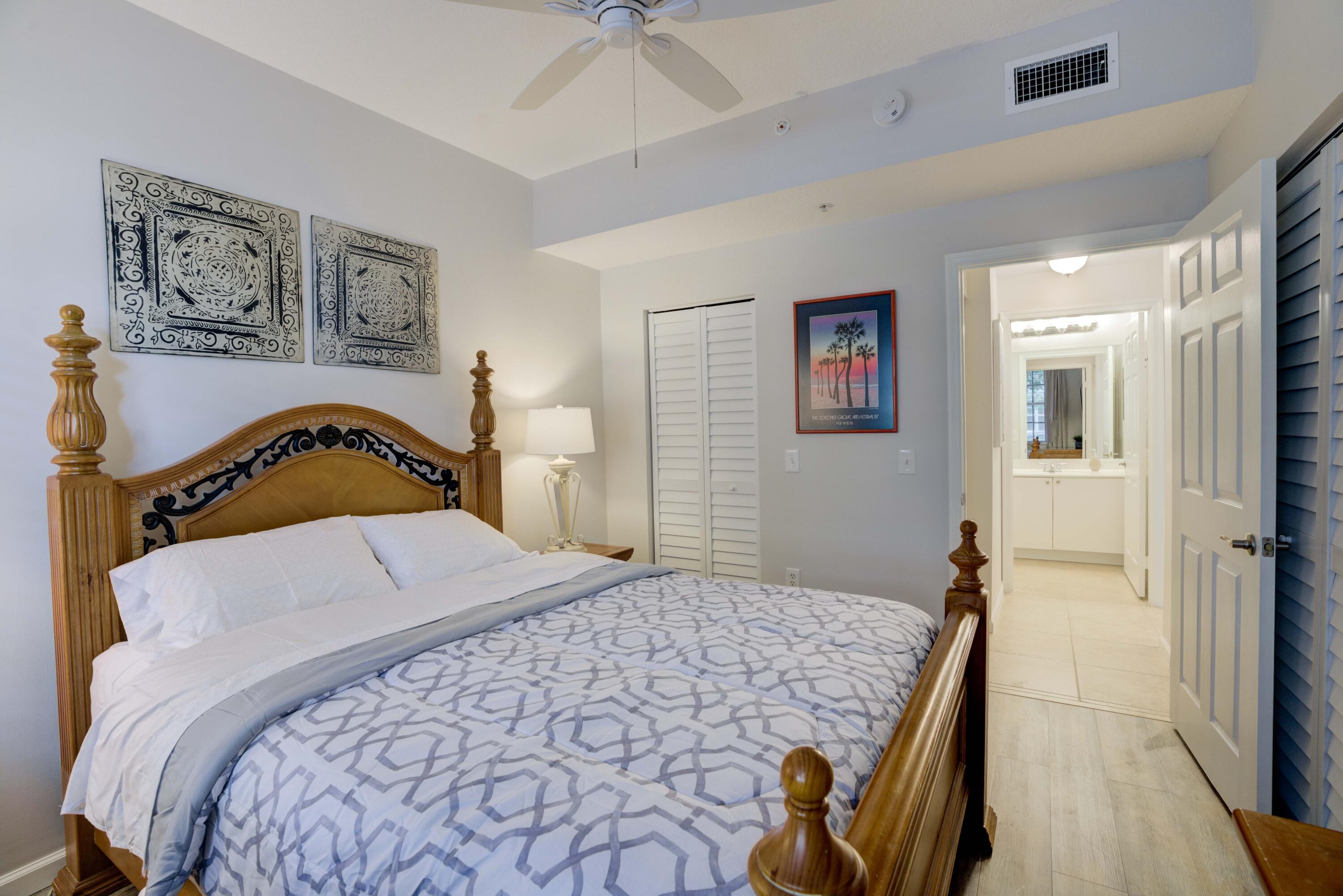 4736 Chancellor Drive, Unit 11 Jupiter, FL 33458 - Photo 16 of 35 a bedroom with a bed and a painting on the wall