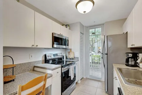 a kitchen with stainless steel appliances granite countertop a stove a sink and a refrigerator