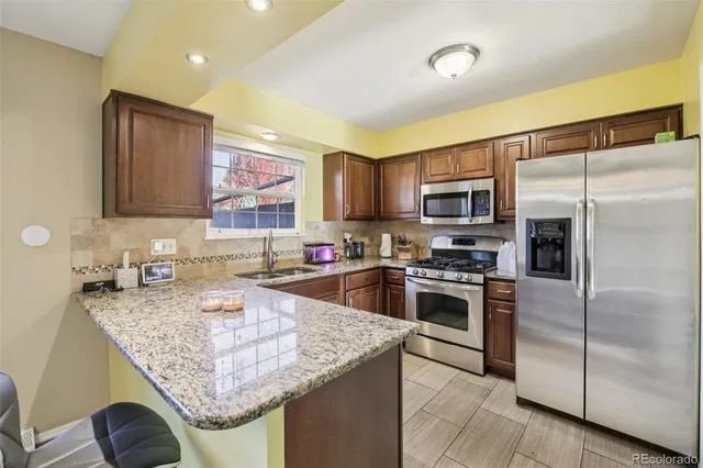 a kitchen with stainless steel appliances granite countertop a sink refrigerator and microwave